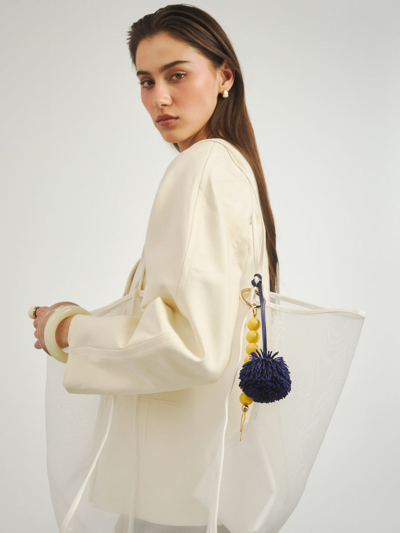  Granatowy brelok pompon do torebki przypięty razem z żółtym brelokiem z żywicznych kul 