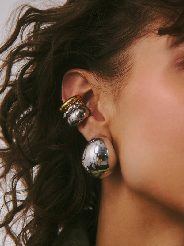 Stylizacja z wieloma srebrnymi i pozłacanymi nausznicami na jednym uchu z efektownym kolczykiem