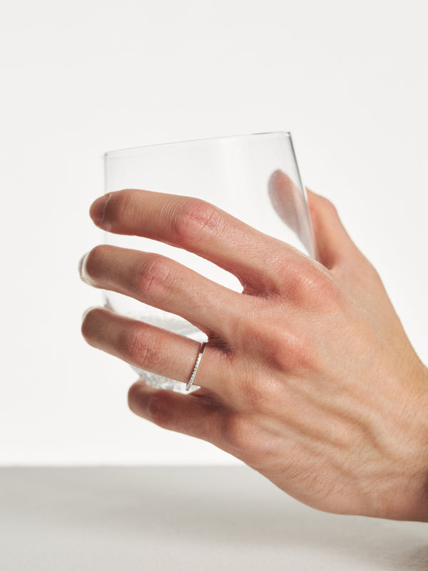 Delikatna złota obrączka z diamentami typu half-eternity na palcu – stylizacja biżuterii Berries.