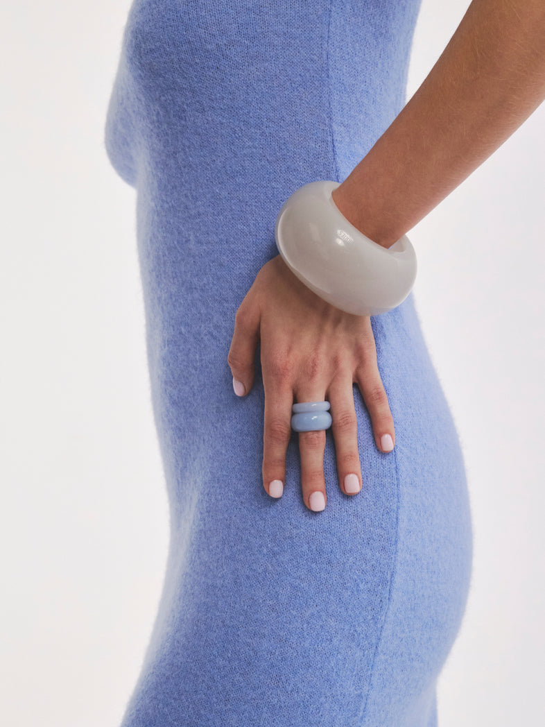  Zestaw dwóch błękitnych pierścionków z żywicy w kolekcji Splash od Berries w outficie z dużą szarą bransoletą  